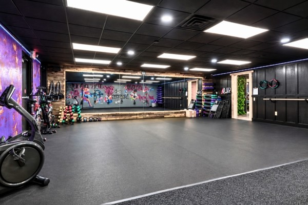 BodyByFlo group fitness studio with mirrored wall, mural and open rubber floor