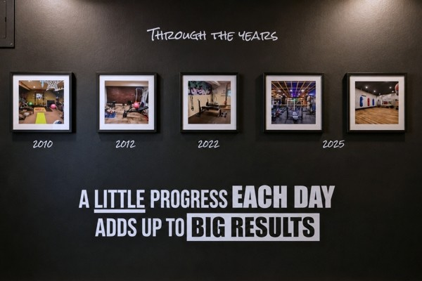 Through the Years wall at BodyByFlo with framed photos from 2010 to 2025