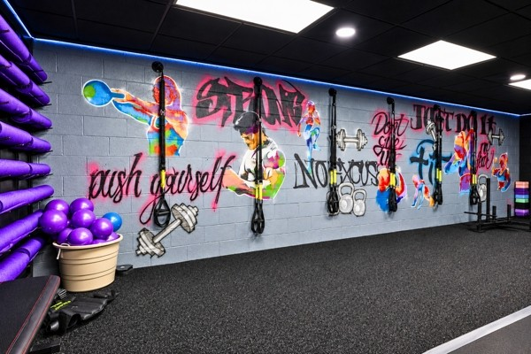 Graffiti mural wall reading Push Yourself and Just Do It with suspension trainers and med balls