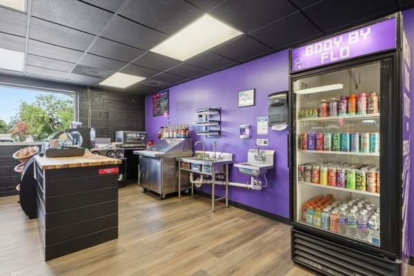 BodyByFlo smoothie bar with prep counter, coolers and stocked drink fridge