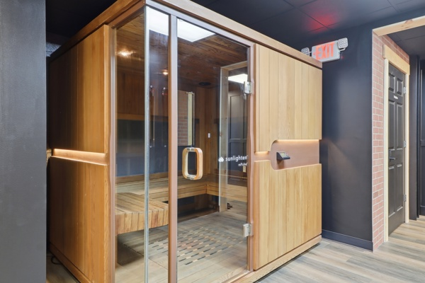 Cedar infrared sauna cabin with glass door in the BodyByFlo recovery area