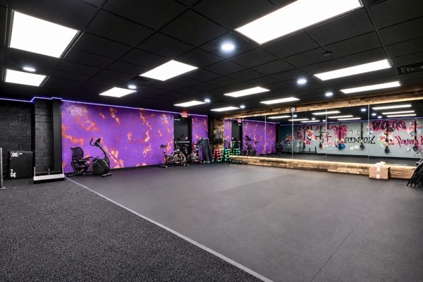 BodyByFlo studio with purple mural wall, bikes and mirrored training floor