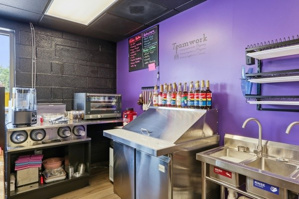 Smoothie bar prep station with blenders, syrups and a stainless steel counter